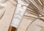 Vivier Sheer Mineral SPF 30 sunscreen tube placed on a textured beige surface with draped white fabric and palm leaf shadows. Promotional text on the left says receive a free Vivier Sheer Mineral SPF 30 with the purchase of any 2+ Vivier products.