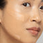 Close-up of a person's face with clay mask application on the cheek