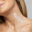 Close-up of a woman's neck with a small amount of white cream applied.